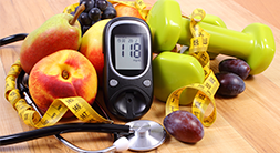 fruit, a diabetes monitor, weights and a tape measure