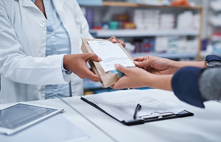 Farmacéutica entregando un medicamento recetado a un cliente