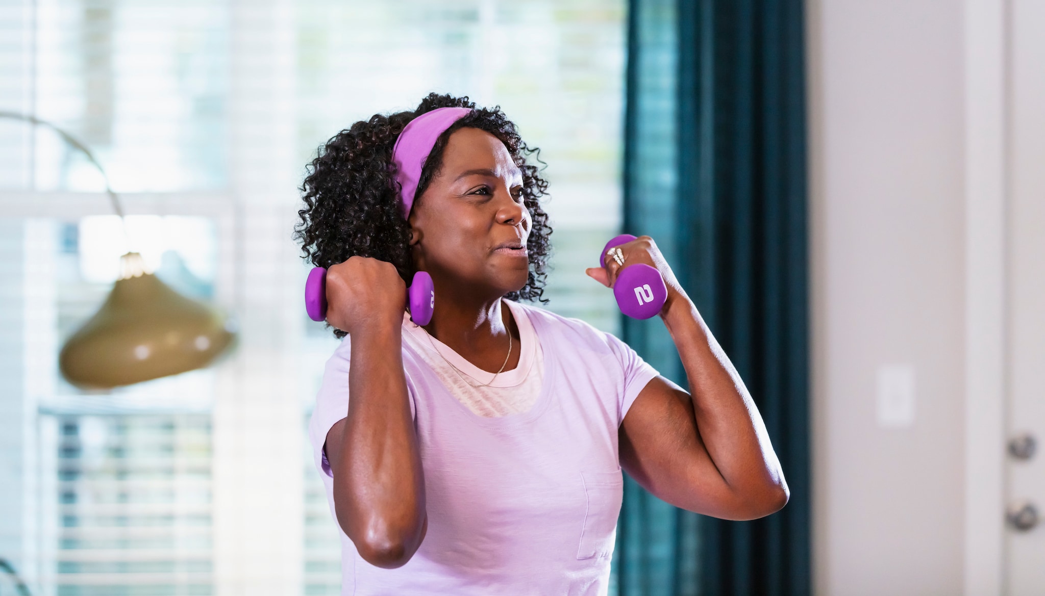 Senior woman working out at home in her living room