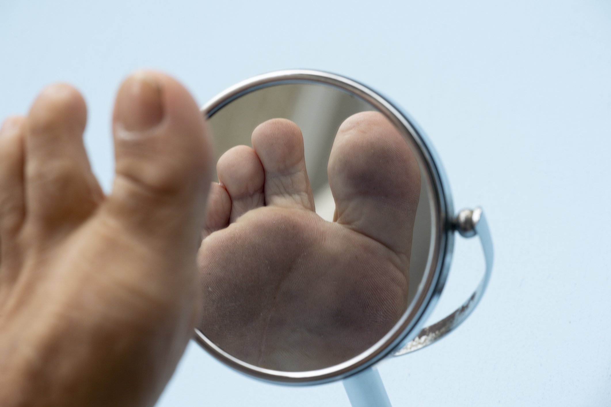 low section of man by mirror against blue background