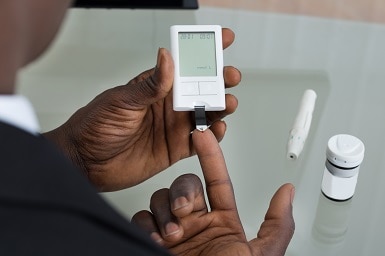 Paciente, manos y glucosemetro.