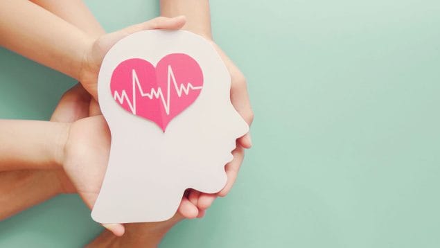 Group of hands holding a paper heart-shaped brain cut out symbolizing a healthy brain.
