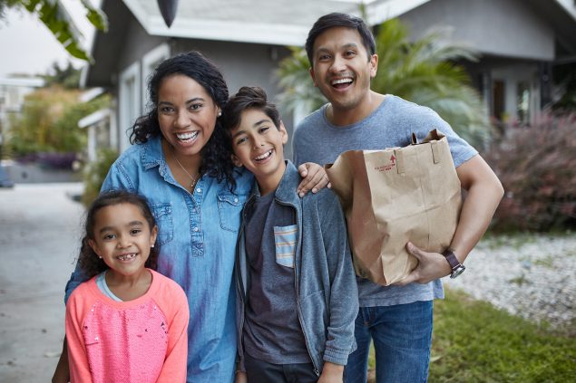 Familia latina feliz después de hacer las compras.