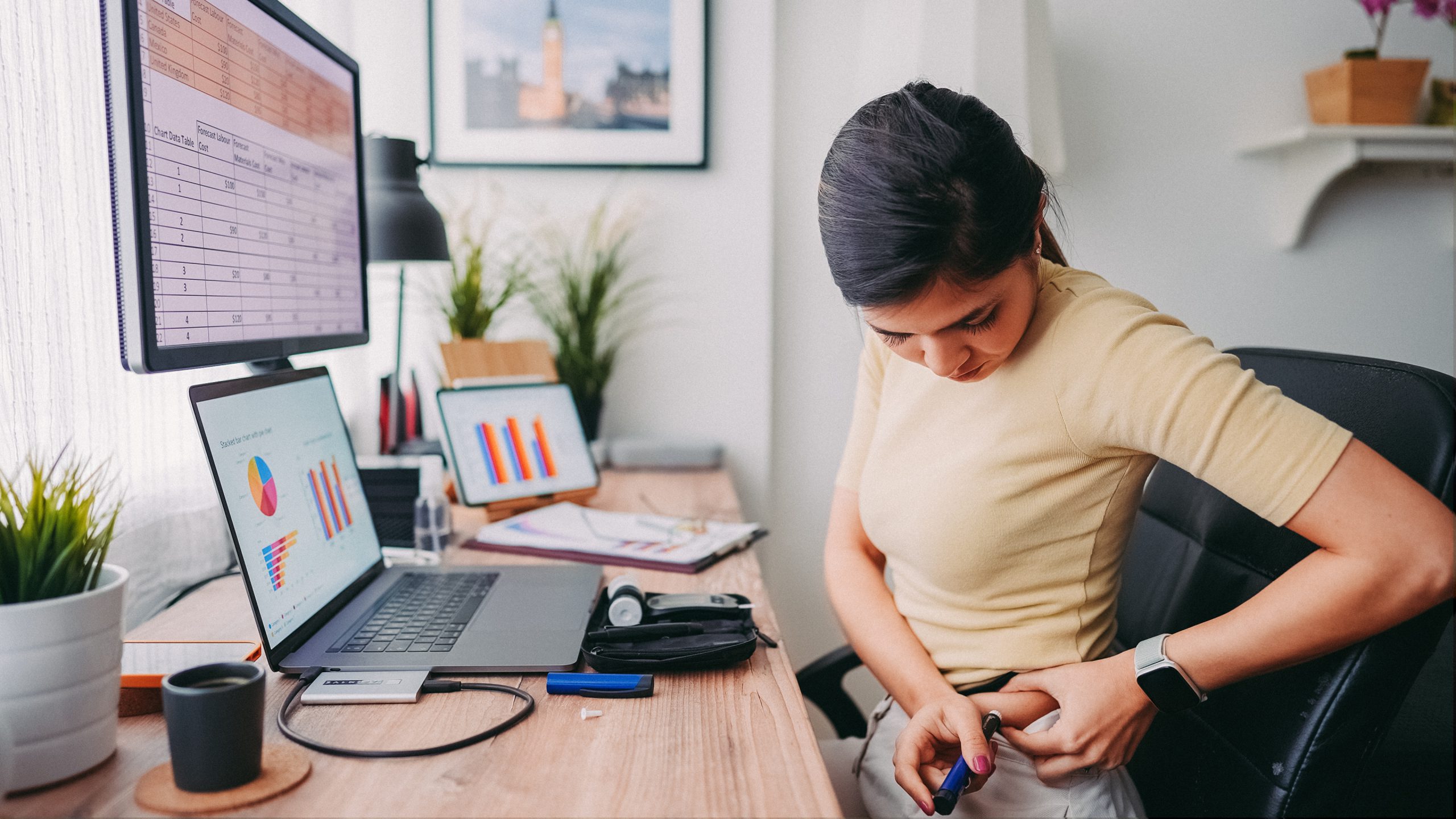 Una mujer en su oficina inyectándose con una pluma de insulina.