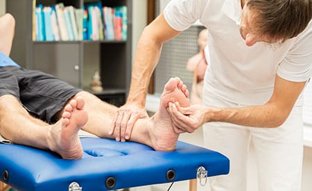 Podiatrist checking a patients feet for sensitivity