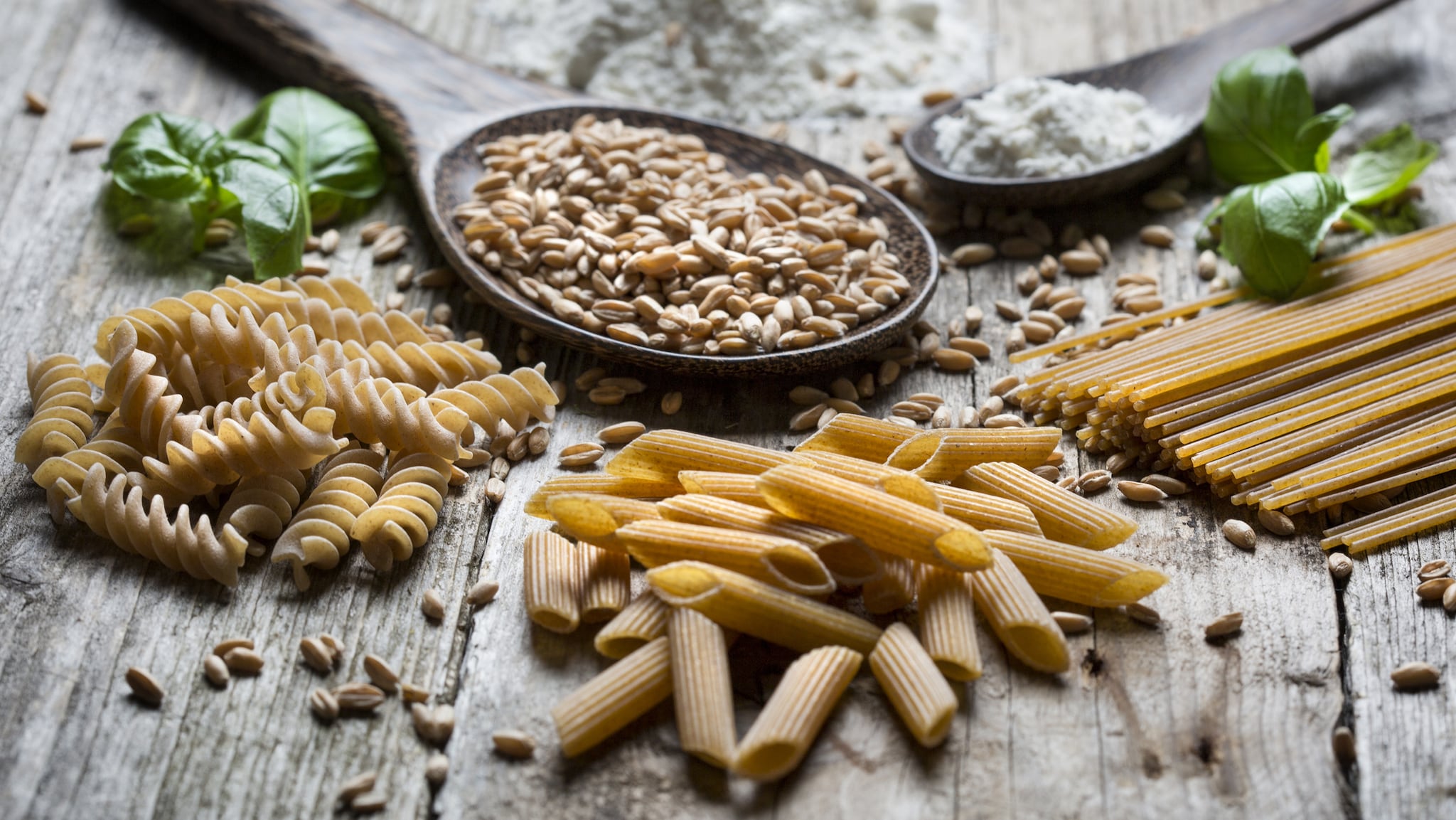 Mixed wheat and white pasta laid out on a table