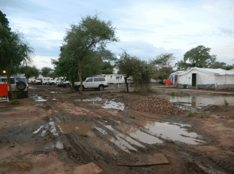 pools of standing water near refugee camp tents
