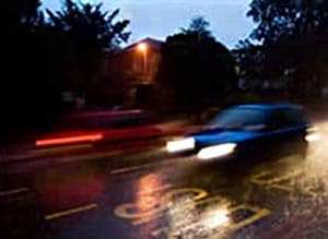 Car Driving on Dark, Wet Road