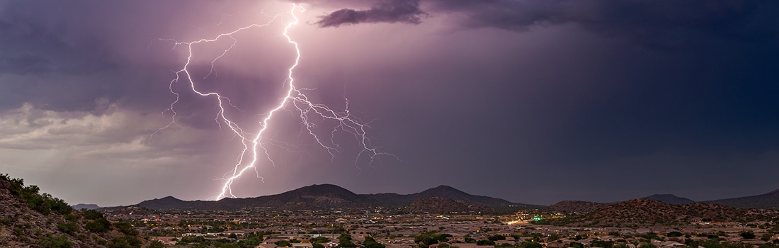 Lightning bolts touch the ground near a city