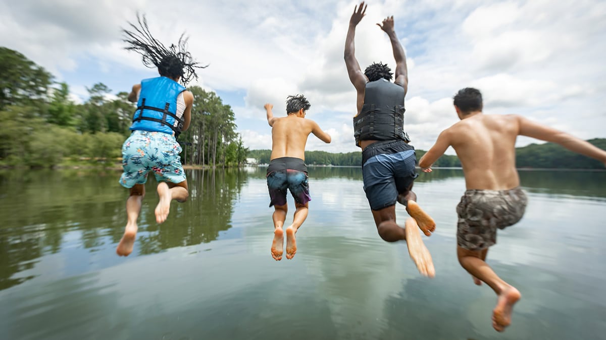 Young men jumping in a lake