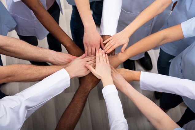 photo of people stacking hands together