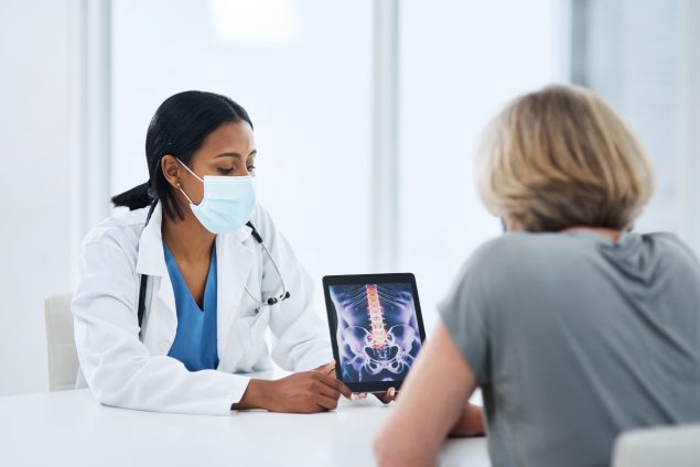 photo of a doctor showing a patient an image on a tablet