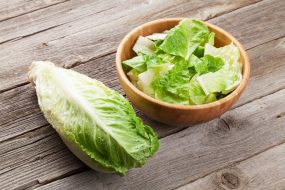 Photo of romaine lettuce in a wood bowl.