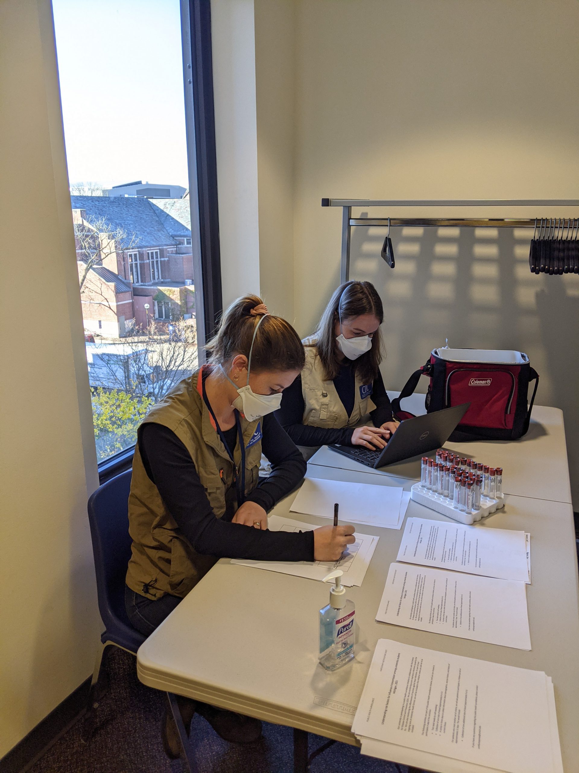 EIS officers Kelsey Sumner (left) and Miranda Delahoy (right) collect student information and specimens to investigate an influenza A outbreak on a university campus during the COVID-19 pandemic in November 2021.