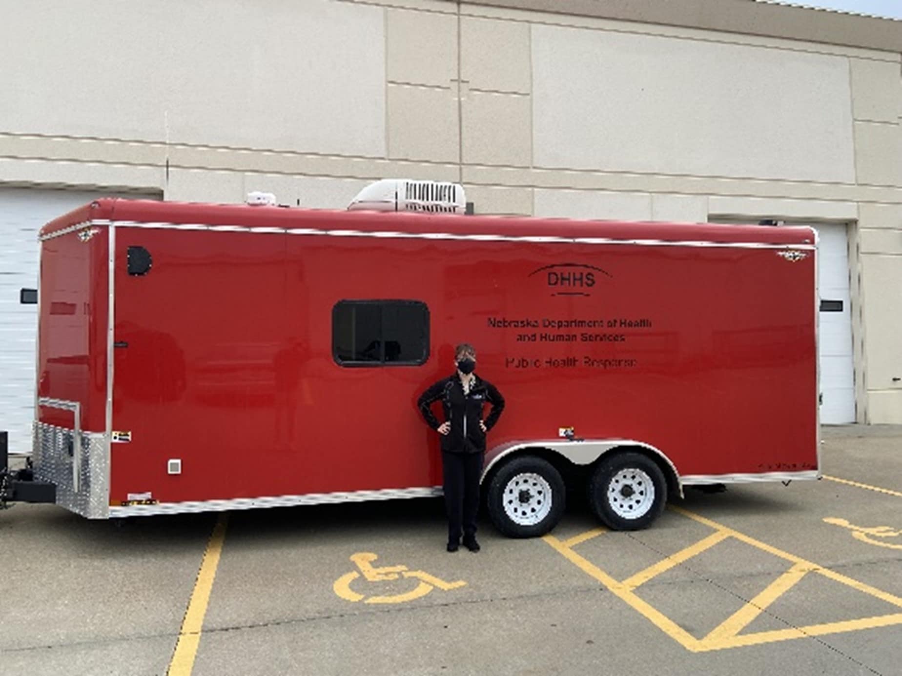 EIS officer Lauren Jansen stands with Nebraska's public health response trailer
