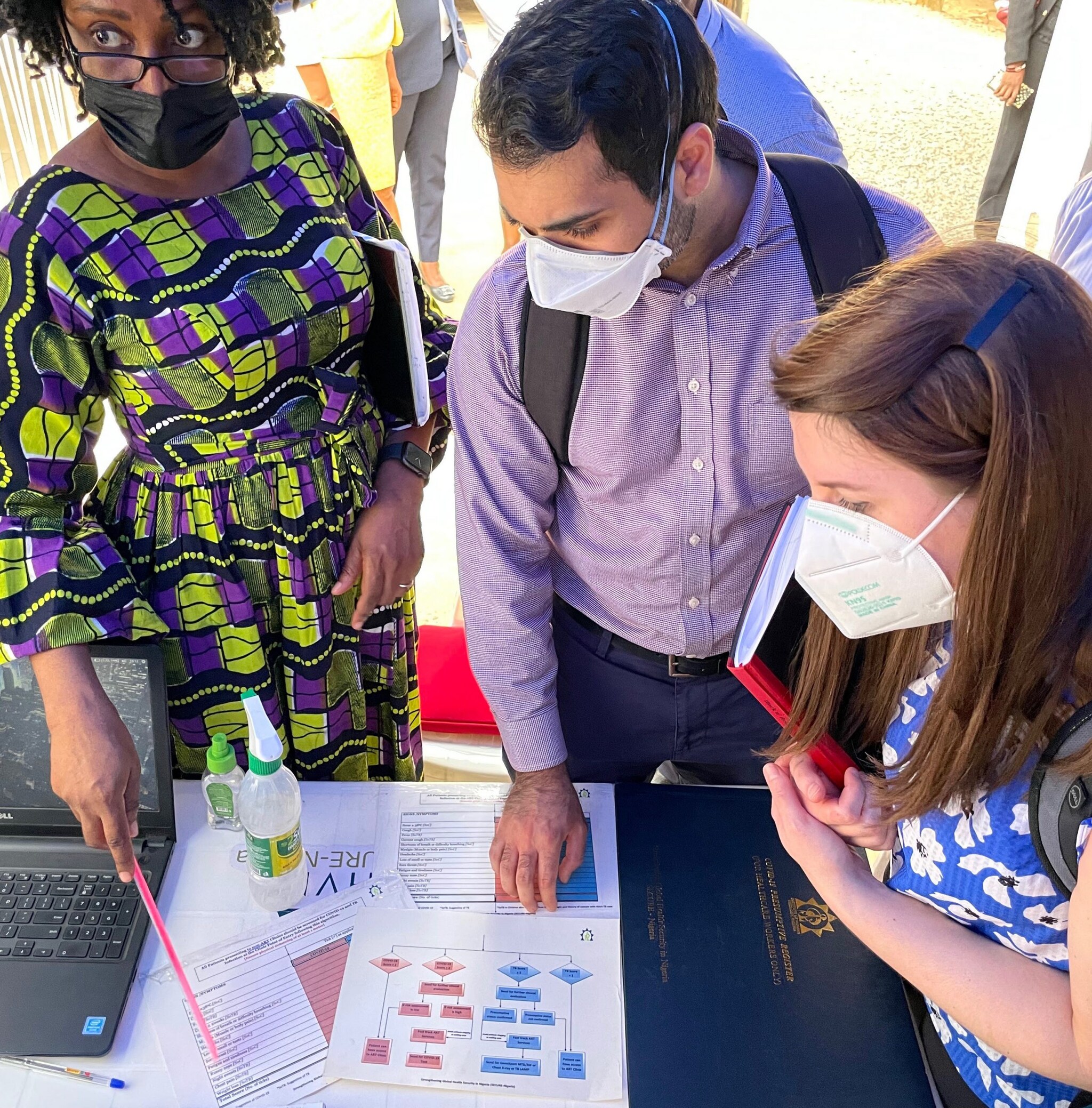 EIS officer Dipesh Solanky reviews materials at a COVID-19 and tuberculosis screening checkpoint outside an HIV clinic in Abuja, Nigeria during a deployment to provide technical assistance in infection prevention and control in February 2022.