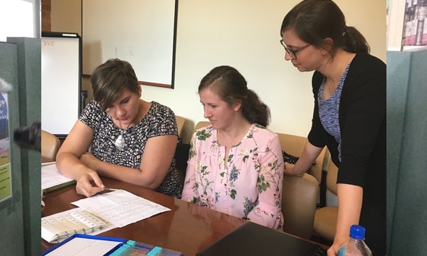Nancy McClung, PhD, EIS Class of 2017 (right), and colleagues reviewing slides of cervical biopsy specimens before they are sent to the CDC for HPV DNA typing.
