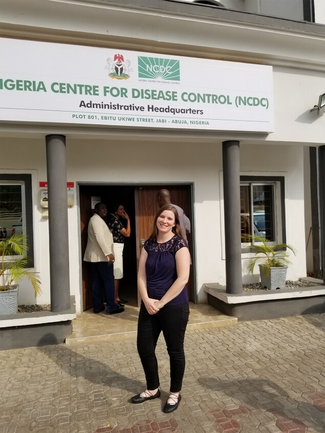 Anna Mandra, DVM, MPH, EIS Class of 2017, stands in front of Nigeria Centre for Disease Control Headquarters in Abuja, Nigeria.