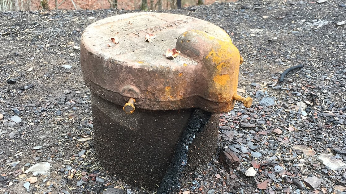 A photograph of a charred wellhead.