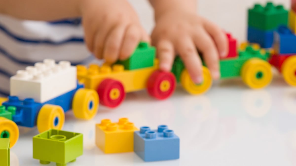 Close-up view of a young child playing with colorful toys.