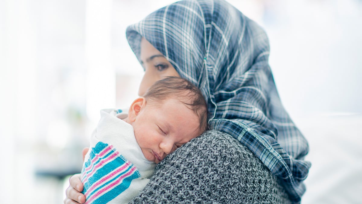 Mother wearing hijab and holding young infant
