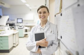 caucasian woman in labcoat standing in a hospital.