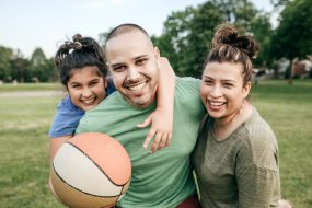 Family in a park holding a basketball