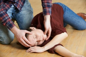 Man placing woman In the recovery position during a seizure