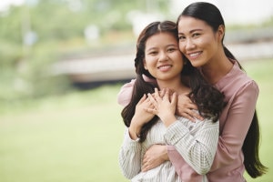 Asian mother hugging her daughter