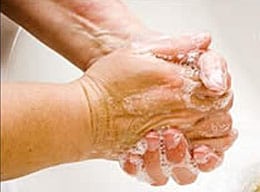 Lavarse las manos con agua y jabón en un lavamanos.