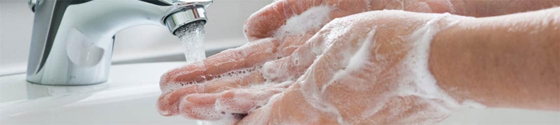  Un hombre lavÃ¡ndose las manos en un fregadero con agua y jabÃ³n.