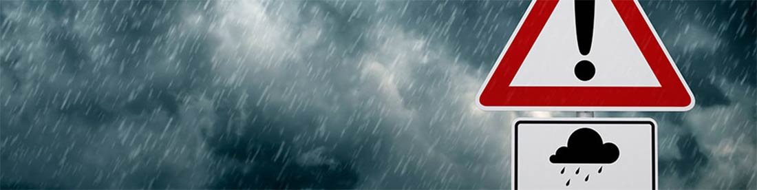 Una señal de precaución con una mala tormenta en el fondo