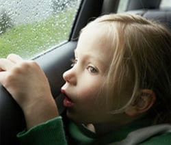 Foto de una niña que mira por la ventana de un automóvil
