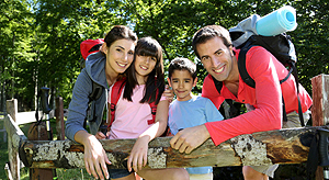 Una familia sale de excursión al bosque llevando mochilas
