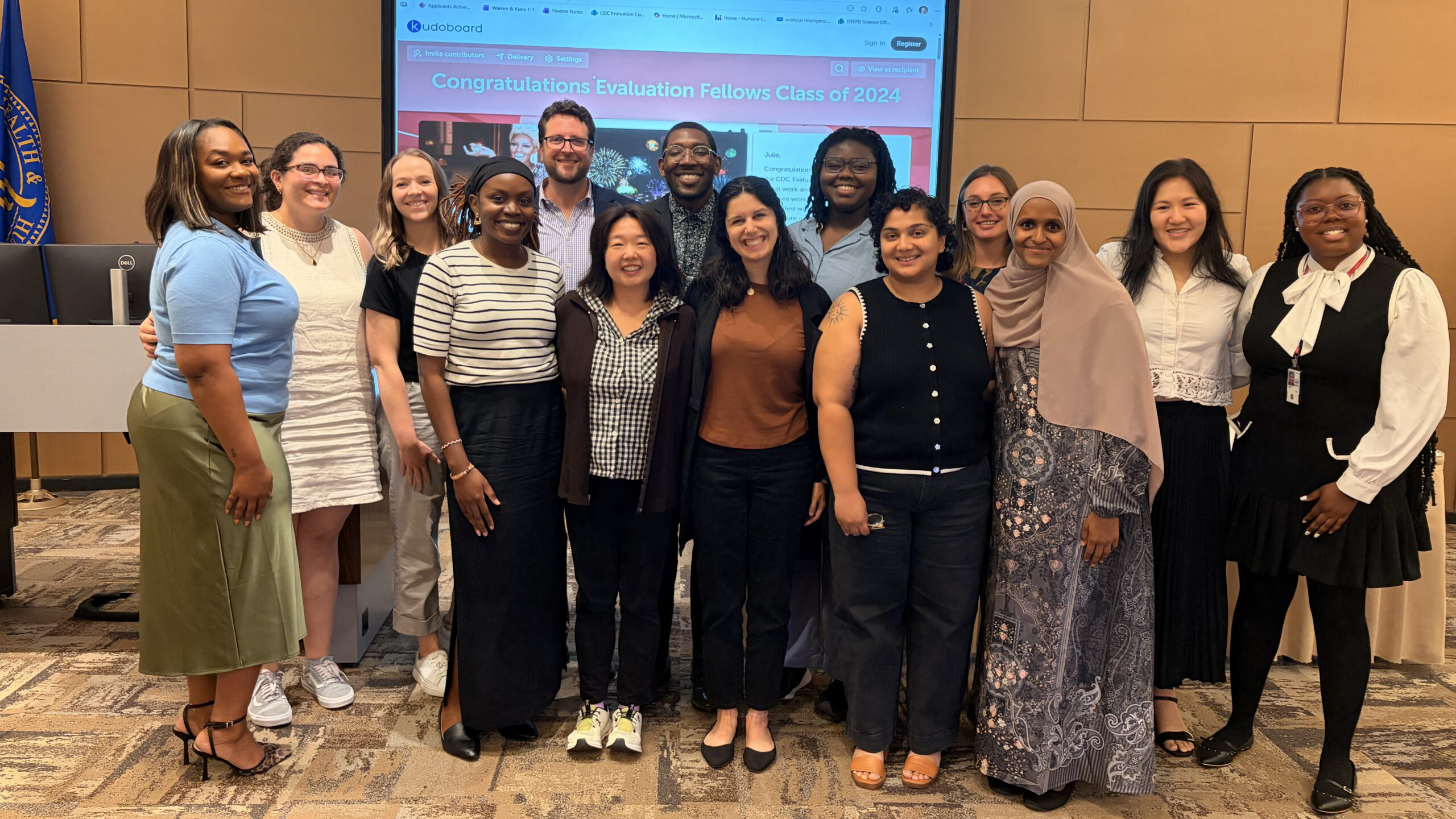 Standing group photo of 14 Evaluation Fellows and EFP staff at the graduation for the Class of 2024.
