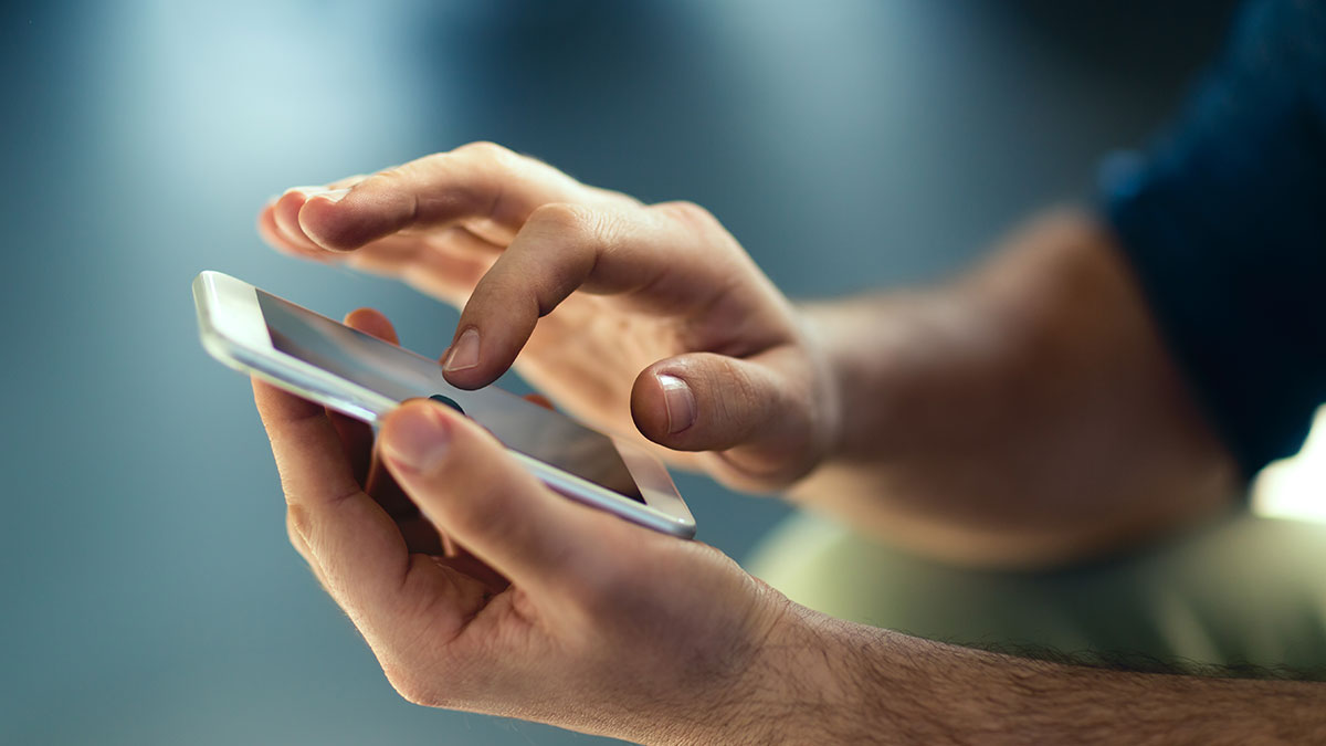 Hands typing on their smartphone.