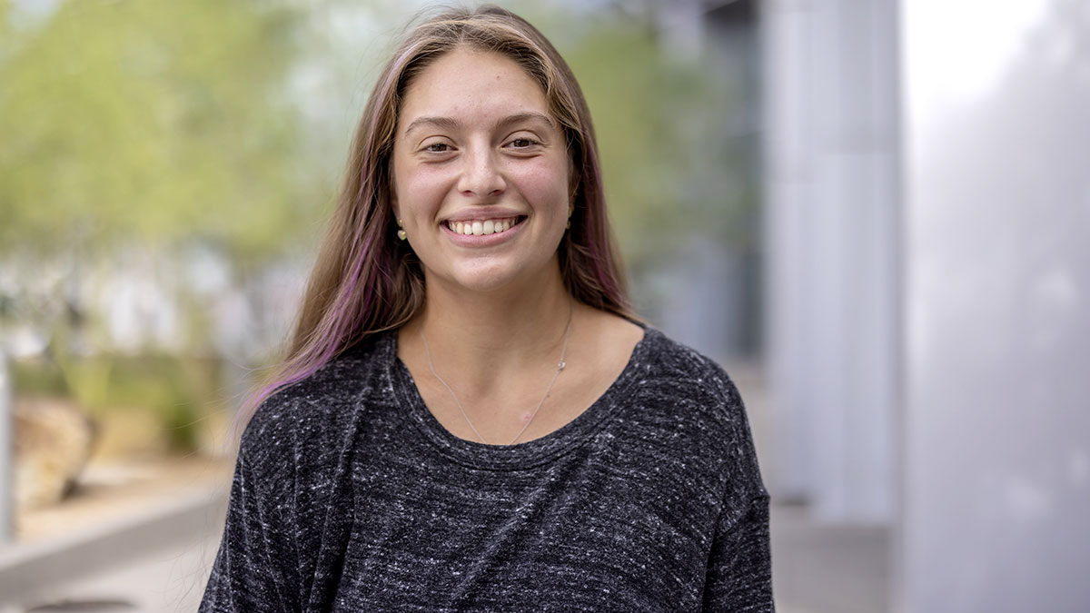 Young woman smiling in front of a window.