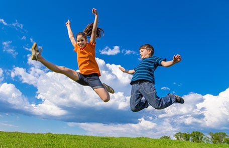 Young girl and boy jumping 