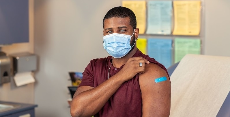 Hombre que recibió la vacuna inyectable contra la influenza mostrando su apósito