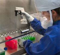 A CDC scientist uses a pipette to transfer H7N9 virus into vials for sharing with partner laboratories for public health research purposes.