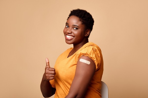 Smiling Black Woman Showing Vaccinated Arm And Thumbs-Up, Be…
