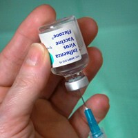 Foto de un vial de la vacuna contra la influenza que está siendo preparado para ser administrado mediante una inyección. Hay disponibles muchos tipos de vacunas contra la influenza.