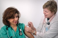 Foto de un trabajador del sector de la salud vacunándose contra la influenza.