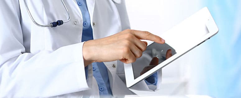 Doctor reviewing guidance on a tablet.