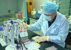 A laboratory technician performs hemaggluttination inhibition (HI) testing. China. 2014-2015 flu season.
