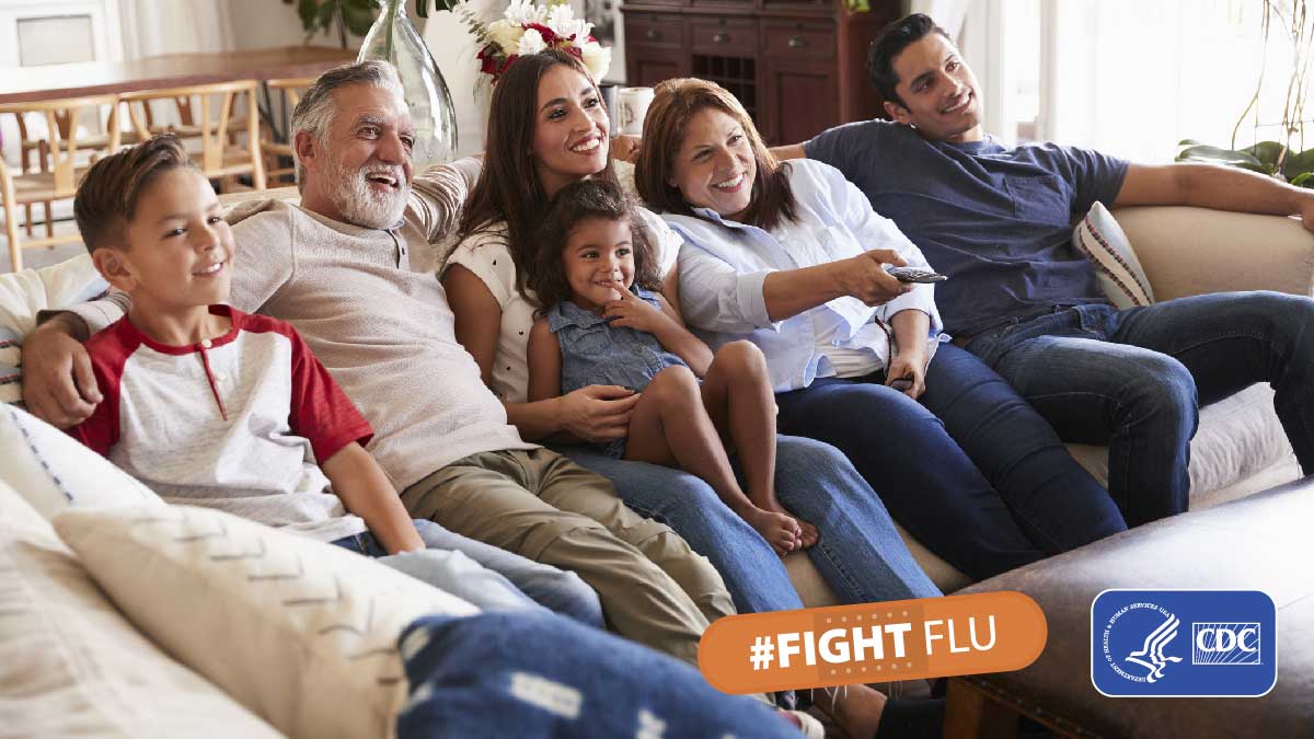 Three generations of a family sitting on couch watching TV with text #fightflu and cdc logo