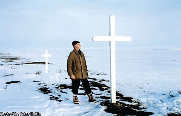 A picture of Johan Hultin at the Brevig Mission gravesite in 1997, 46 years after his first attempt to rescue the 1918 pandemic flu virus. Hultin saw that the small crosses that previously covered the site were missing, so Hultin built two large crosses (shown above) within the woodshop of a local school to mark the gravesite. Photo credit: Johan Hultin.