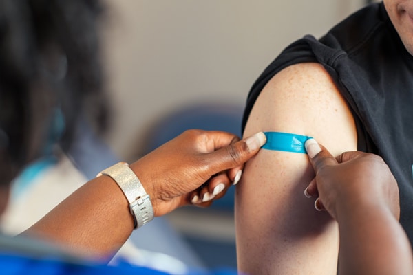Health professional applying band aid after vaccination