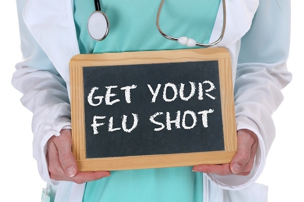 Doctor holding sign that reads: Get your flu shot