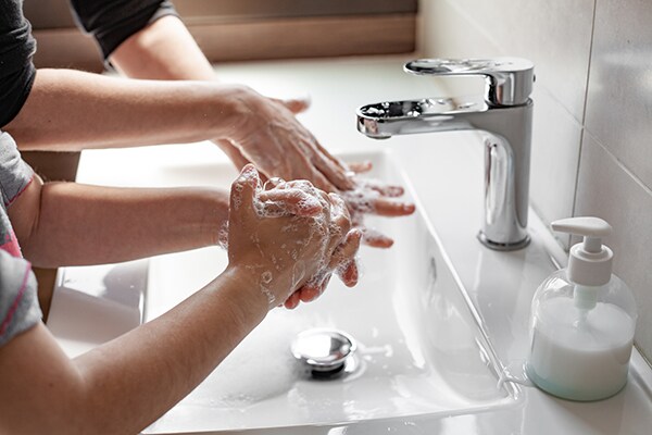 Madre e hija lavándose las manos con jabón